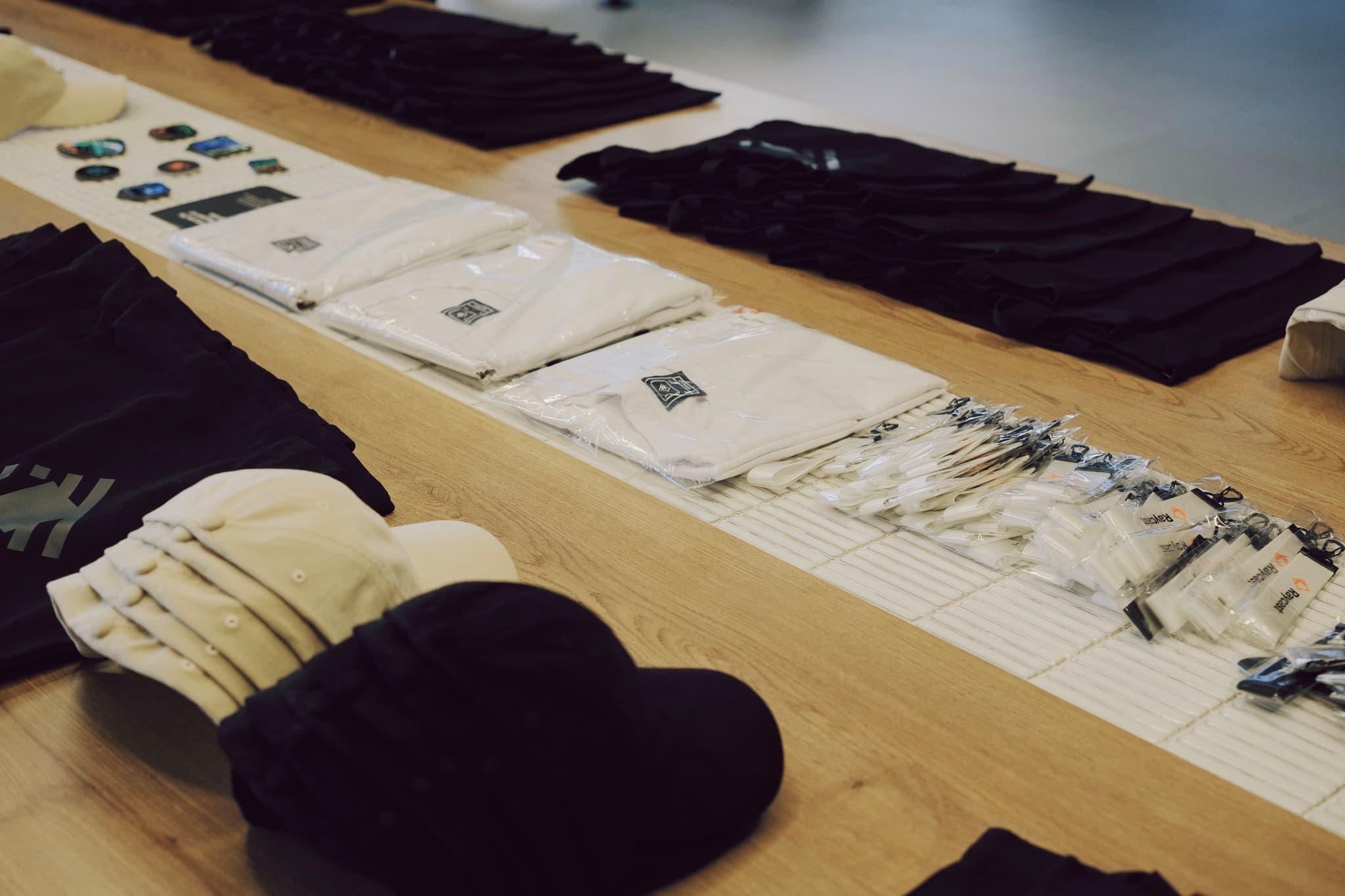 Tabletop display of conference swag including lanyards name badges pens and baseball caps
