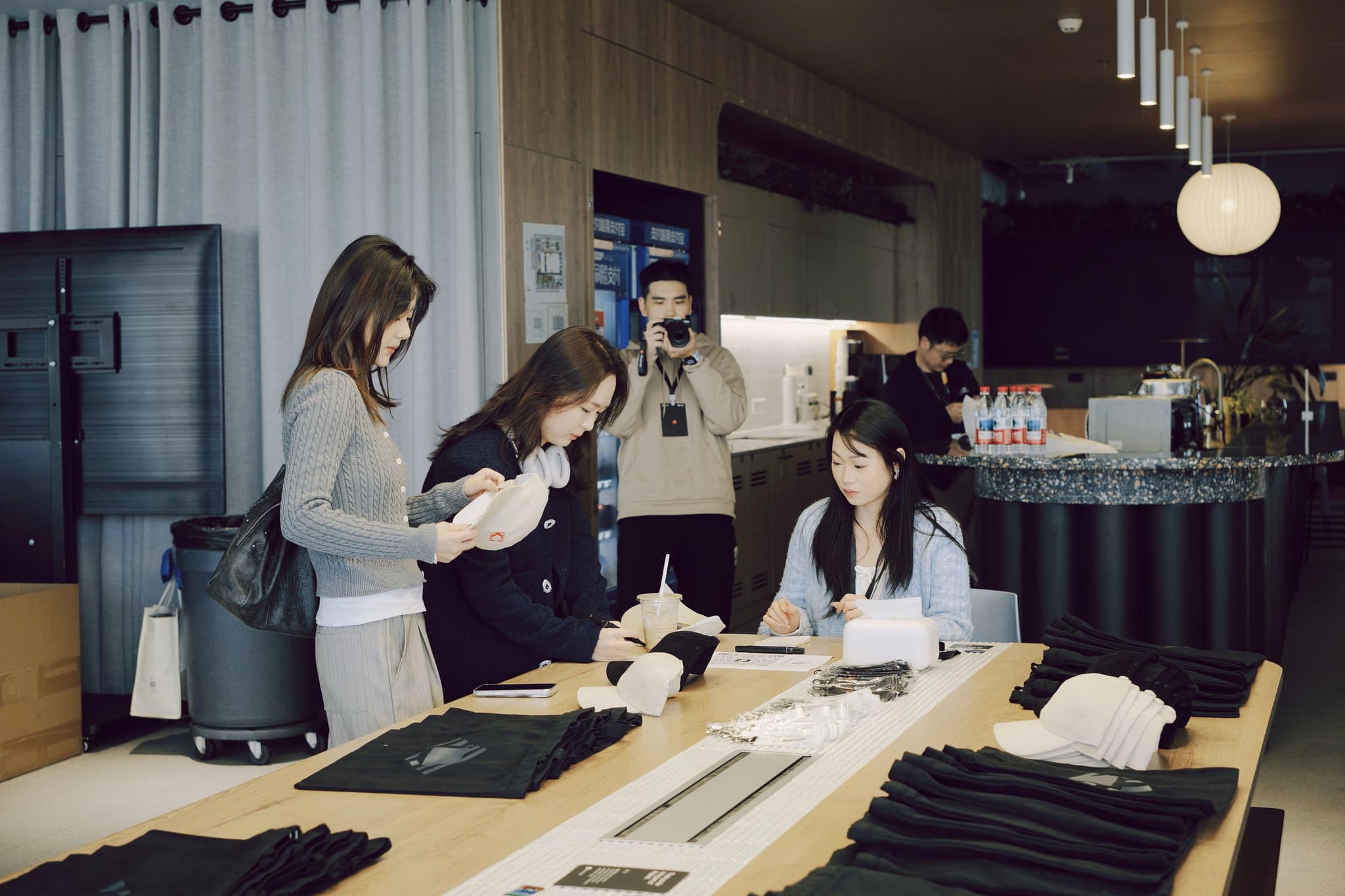 Group of people at a counter signing forms and interacting with staff in a lobby or reception area