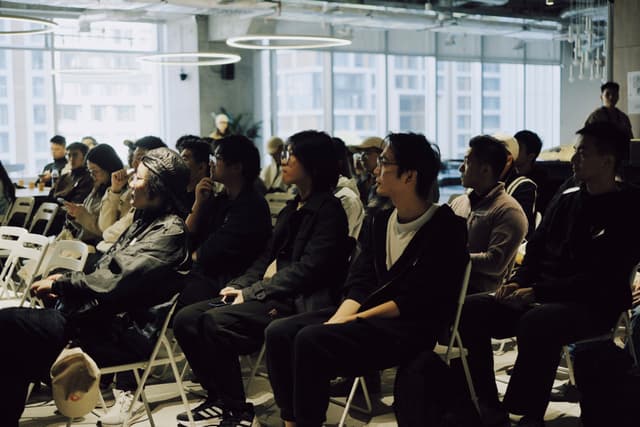 Audience seated in rows watching a meetup presentation in a bright conference room
