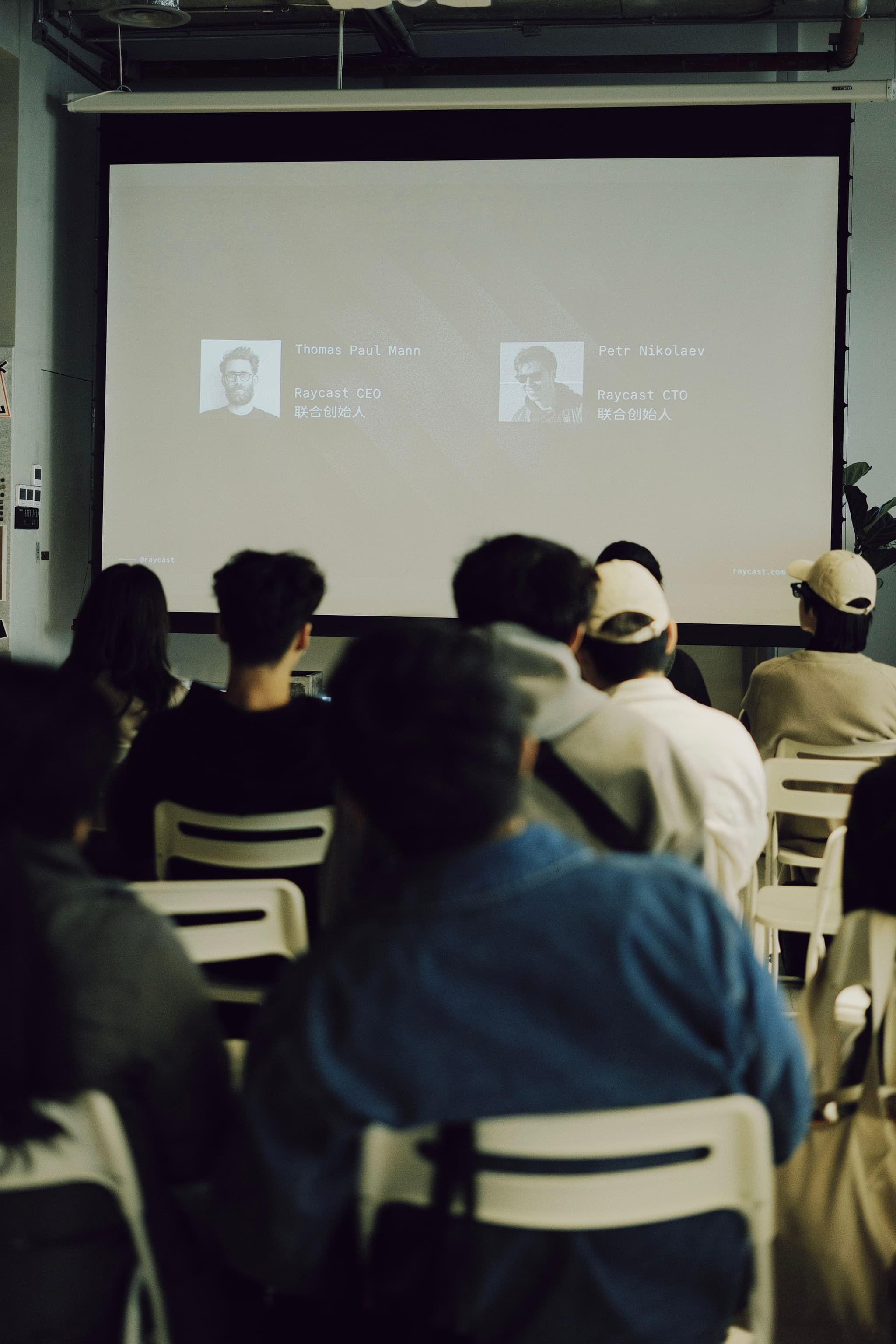 Audience seated in a small room watching a projected presentation screen