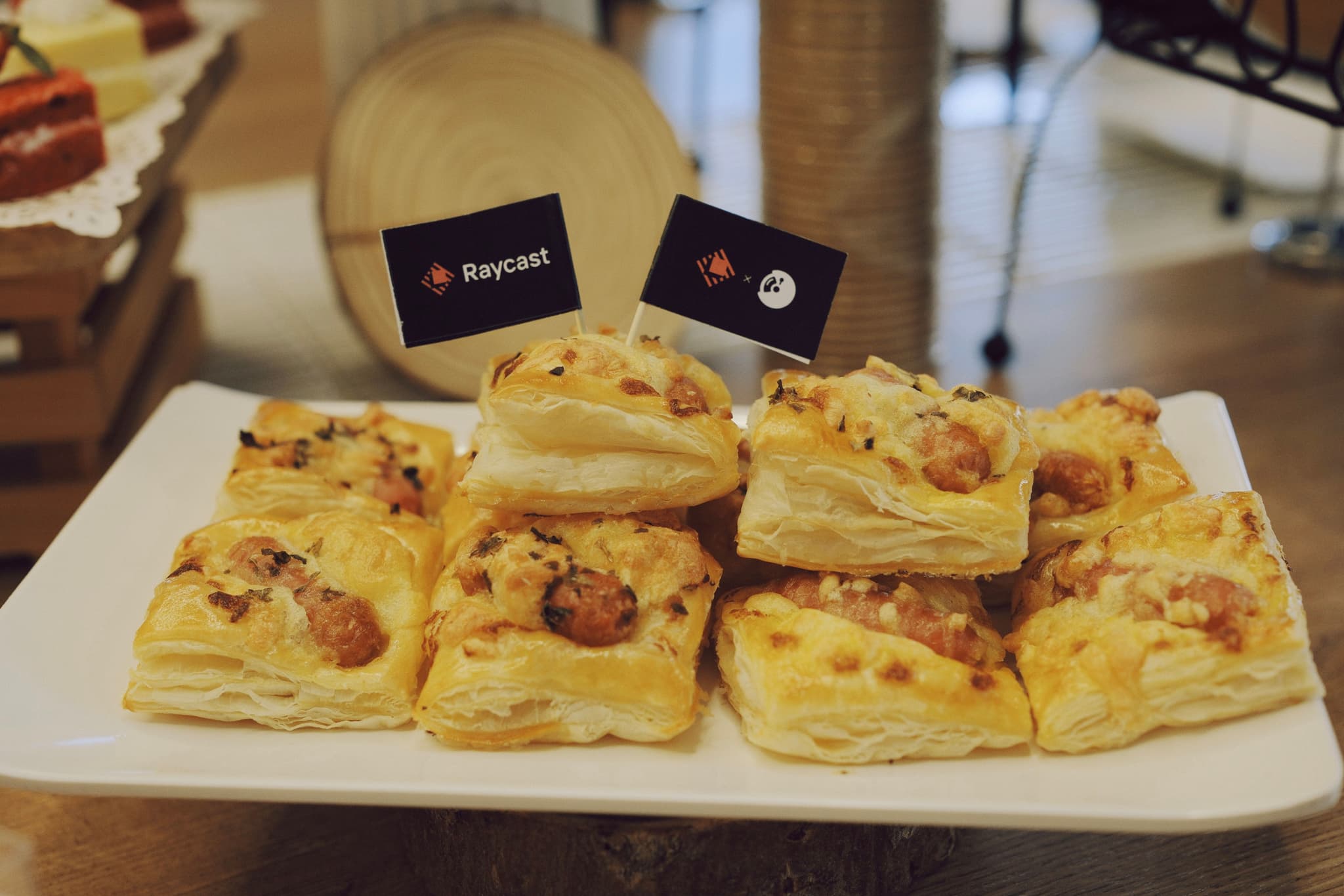 Plate of assorted baked pastry squares on a table with small cards and a bowl in the background