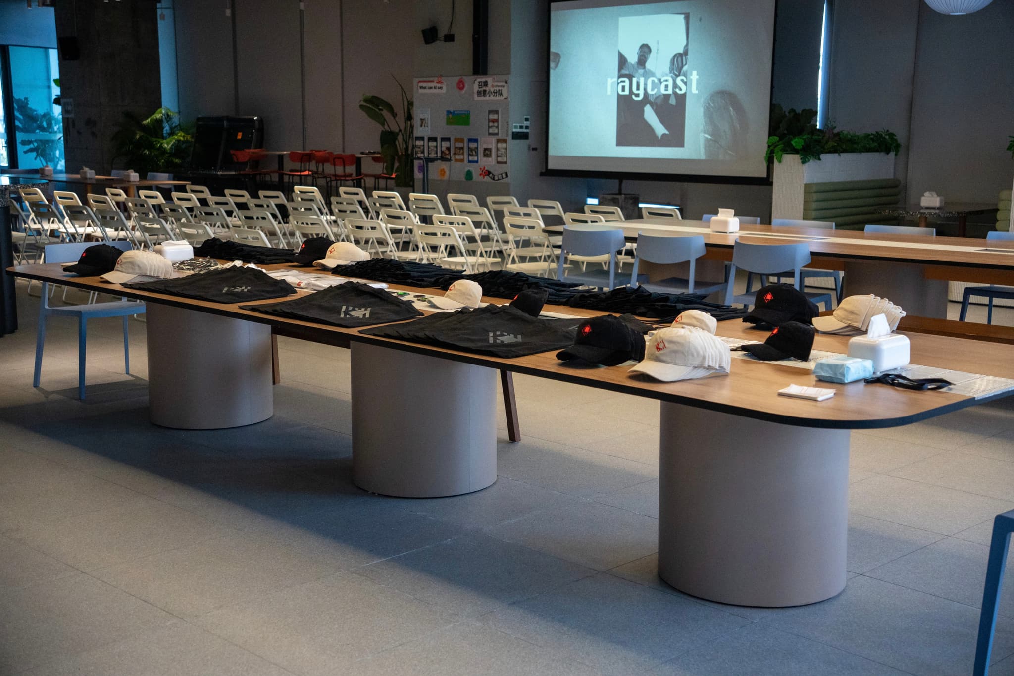 Modern conference room with U shaped tables set with materials and a projection screen at the front