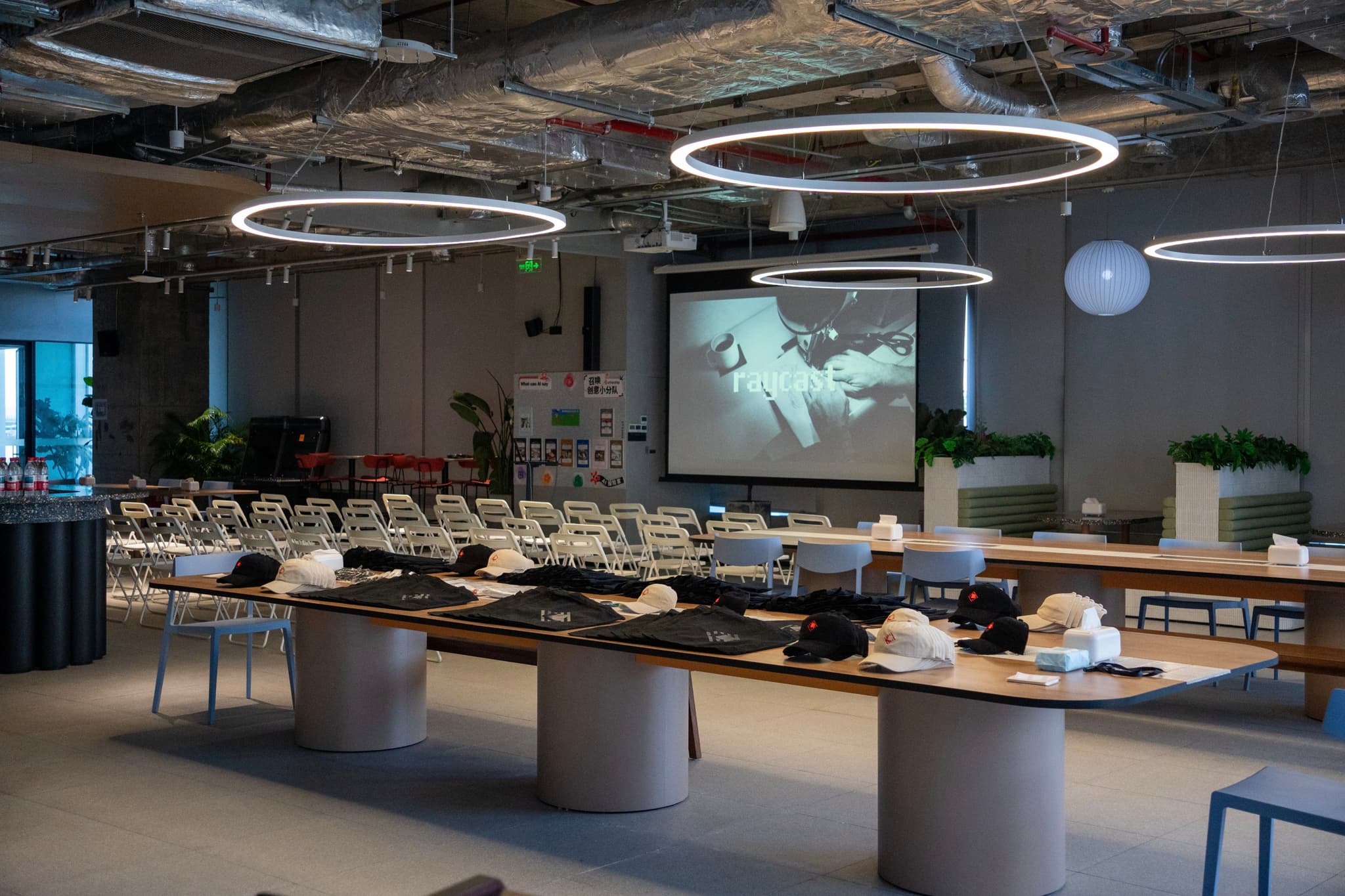 Contemporary restaurant buffet with long serving counters, circular ceiling lights, and a large screen in the background
