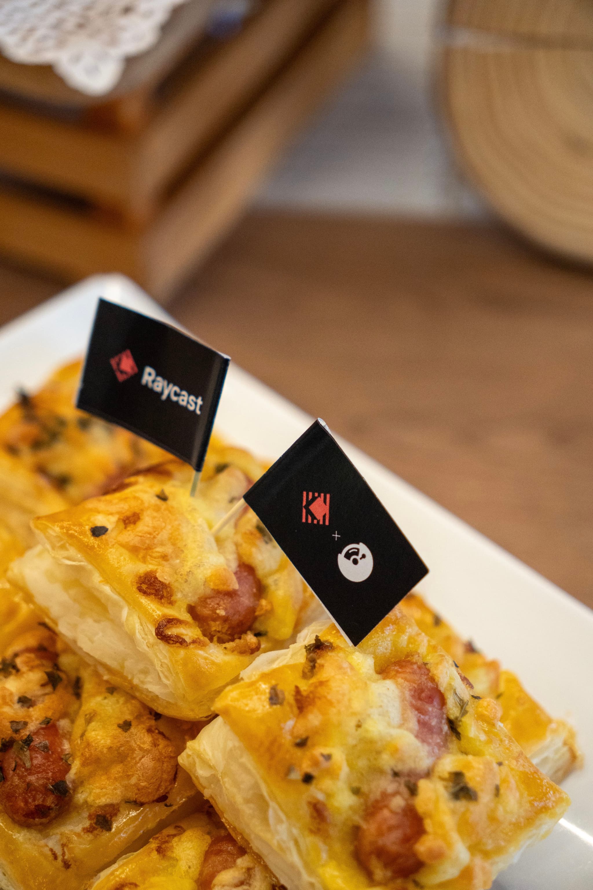 Closeup of cheesy bacon potato skins on a white plate with small black flags and a blurred wooden background