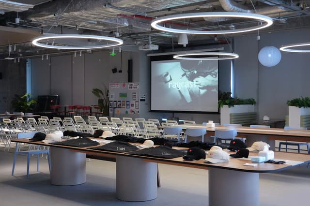 Contemporary banquet hall with long buffet tables circular ceiling lights and a large projection screen