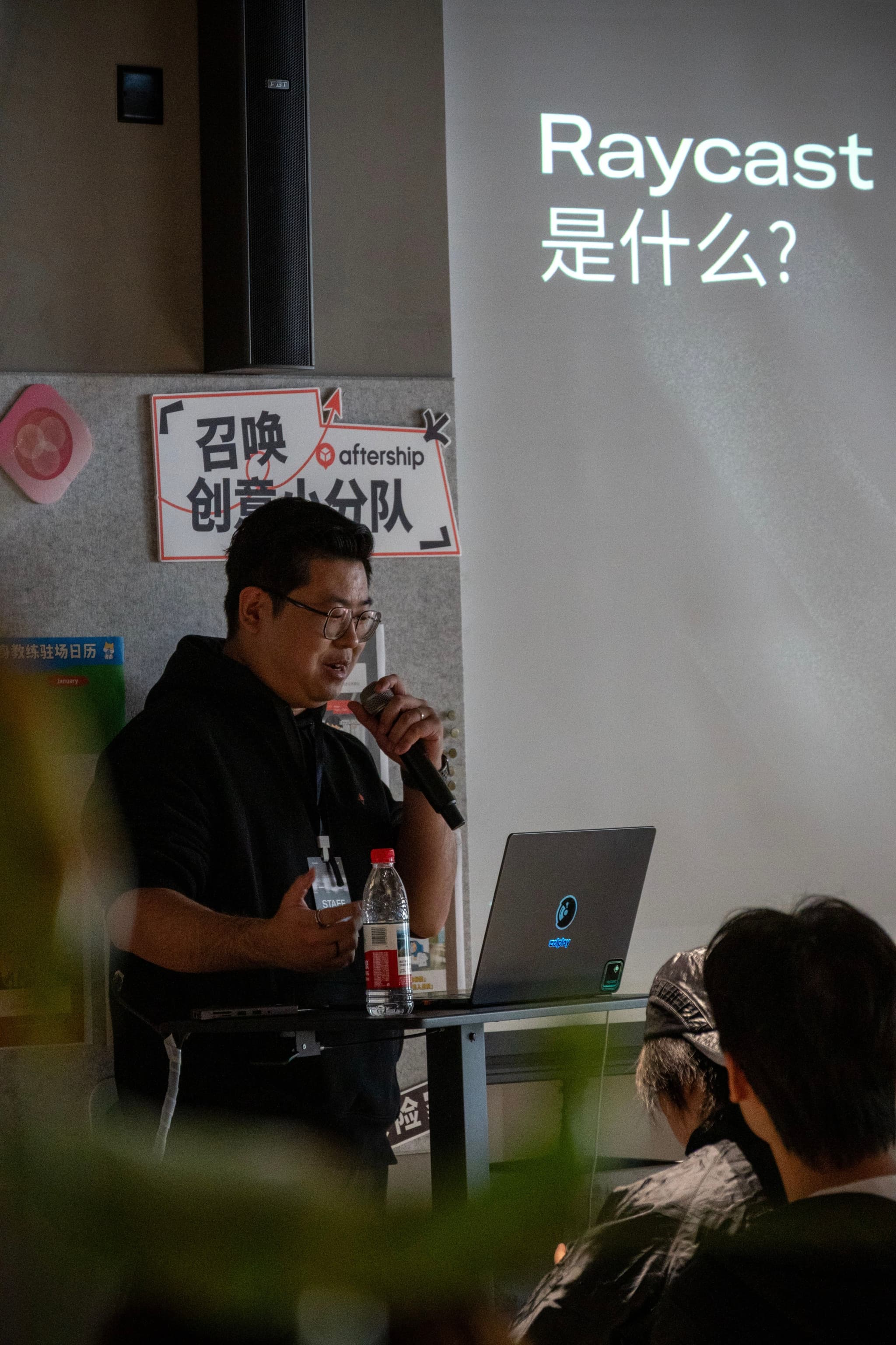 Speaker presenting Raycast topic at a meetup with projected slide in Chinese